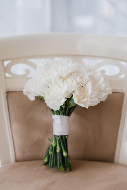 Schöner großer Hochzeitsstrauß mit weißen Blumen auf dem Stuhl am Hochzeitstag