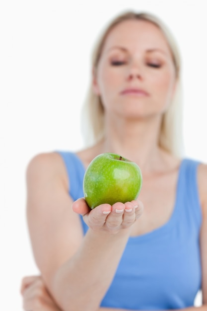 Schöner grüner Apfel gehalten von einer blonden Frau