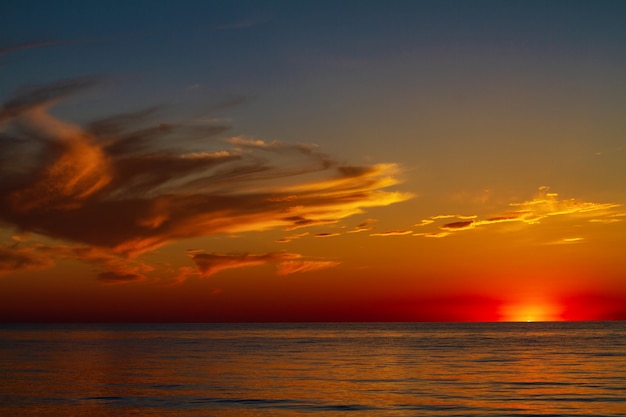 Schöner Himmel mit Wolken bei Sonnenuntergang über dem Meer