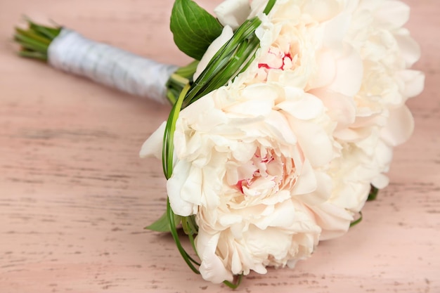 Schöner Hochzeitsblumenstrauß auf farbigem hölzernem Hintergrund