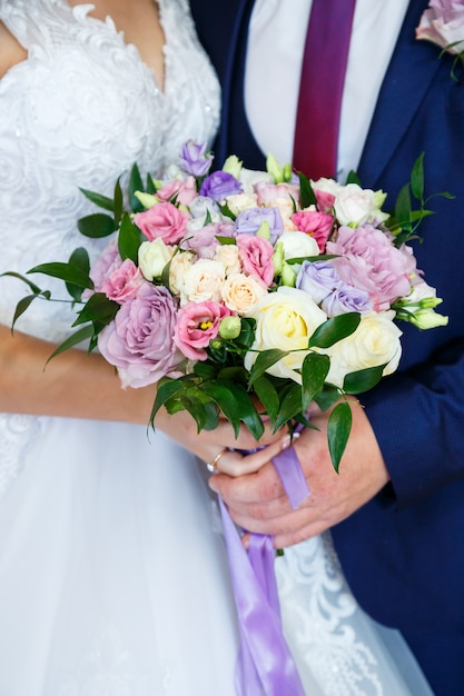 Schöner Hochzeitsblumenstrauß in den Händen des Brautpaares