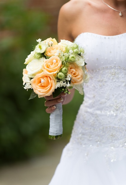 Schöner Hochzeitsrosenstrauß in den Händen der Braut