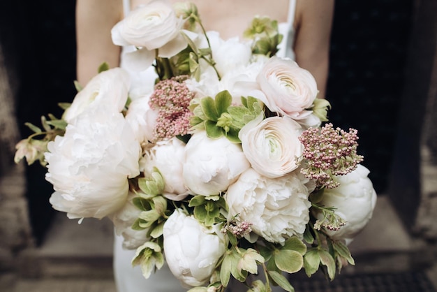 Schöner Hochzeitsstrauß aus Rosen in den Händen der Braut