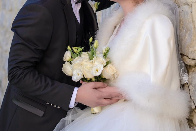 Schöner Hochzeitsstrauß in den Händen der Braut und des Bräutigams schließen oben
