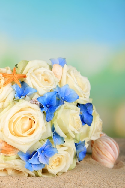 Schöner Hochzeitsstrauß mit Rosen auf Sand, auf Naturhintergrund