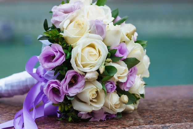 Schöner Hochzeitsstrauß natürlicher Blumen auf einem unscharfen Hintergrund liegt auf Granit