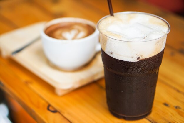 Schöner Iced Americano oder schwarzer Kaffee mit Schaum bilden frische Kaffeebohnen