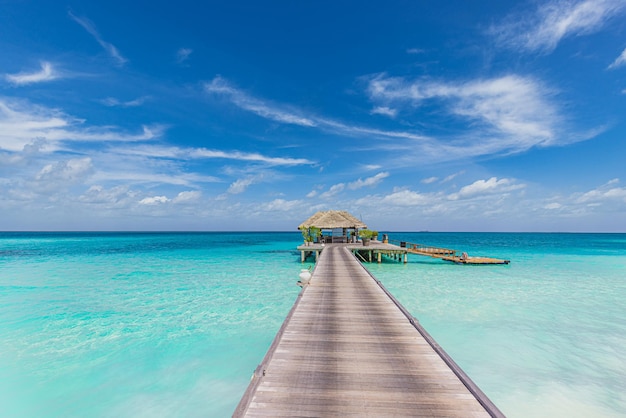 Schöner Inselstrand der Malediven. Palmen, Seesandhimmel, Wasservilla, langer Holzstegweg