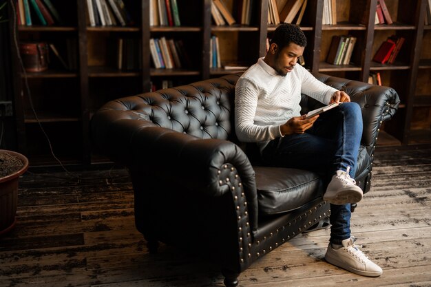 schöner junger afrikanischer Mann, der ein Buch liest