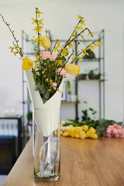 Schöner junger Florist macht einen Blumenstrauß