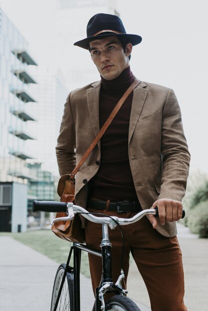 Schöner junger Geschäftsmann mit seinem modernen Fahrrad.