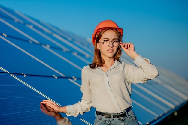 Schöner junger Ingenieur, der nahe Sonnenkollektoren im Freien steht, Green Energy Concept.