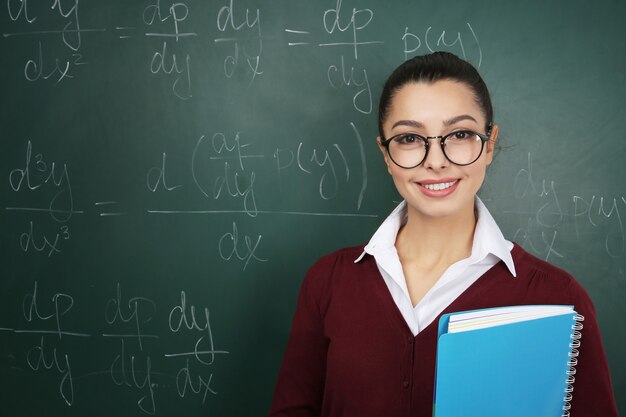 Schöner junger Lehrer nahe Tafel im Klassenzimmer