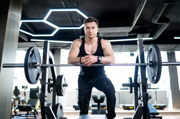 Schöner junger starker Mann im Fitnessstudio. Gesunder Bodybuilding-Mann, der ausarbeitet.