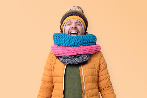 Foto schöner kaukasischer lustiger mann in mehreren hüten und schals, die laut lachen