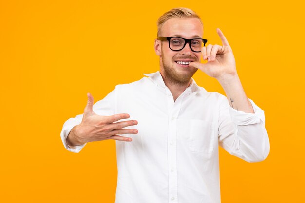 Schöner kaukasischer Mann mit Brille gestikuliert lokalisiert auf Gelb