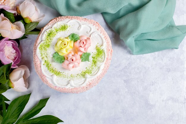 Schöner köstlicher Kuchen verziert mit Blumen in den Pastellfarben auf Holztisch mit Pfingstrosen, Draufsicht