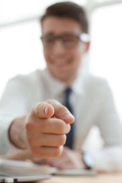 Foto schöner lächelnder geschäftsmann, der mit dem finger auf sie zeigt