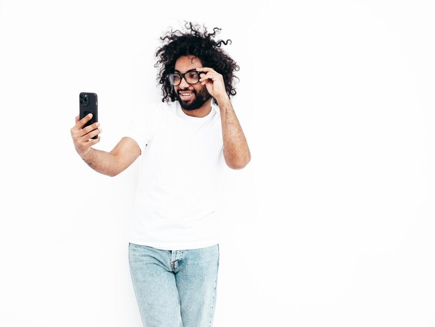 Schöner lächelnder Hipster-Mann, der im Studio posiert