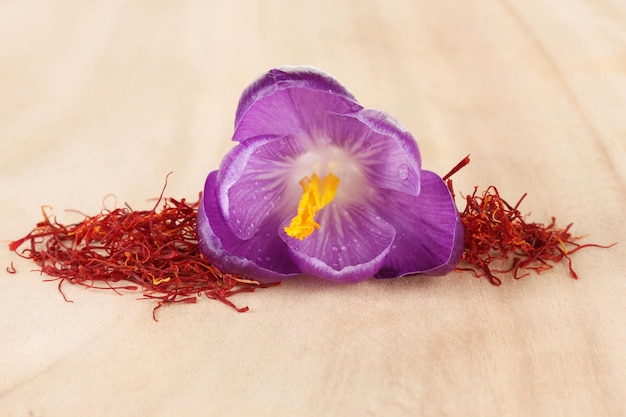 Foto schöner lila krokus und safran auf holzhintergrund