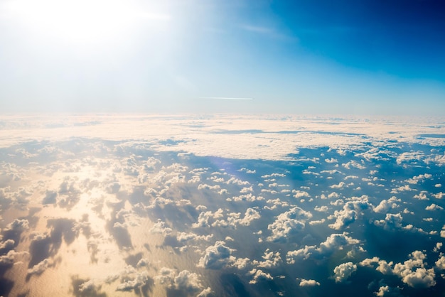 Schöner Luftblick mit blauem Himmel, weißen, flauschigen Wolken und hellen Sonnenstrahlen darüber. Kann als natürlicher Hintergrund verwendet werden