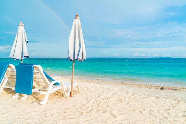 Schöner Luxusregenschirm und -stuhl auf Strand