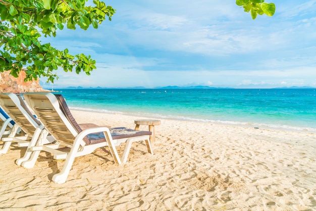 Schöner Luxusregenschirm und -stuhl auf Strand