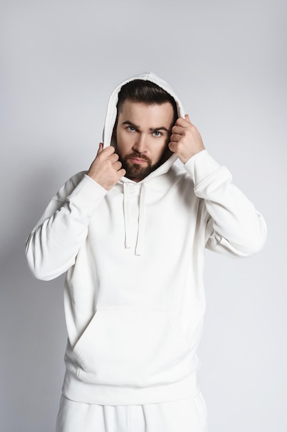 Schöner Mann mit leerem weißen Hoodie und Hose