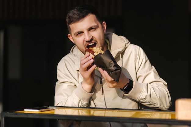 Schöner Mann mit traditioneller Hot-Dog-Küche während der Ruhepause Kaukasischer Typ, der die Straße genießt