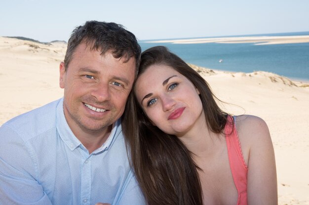 Schöner Mann und Frau, die am Strand lächeln