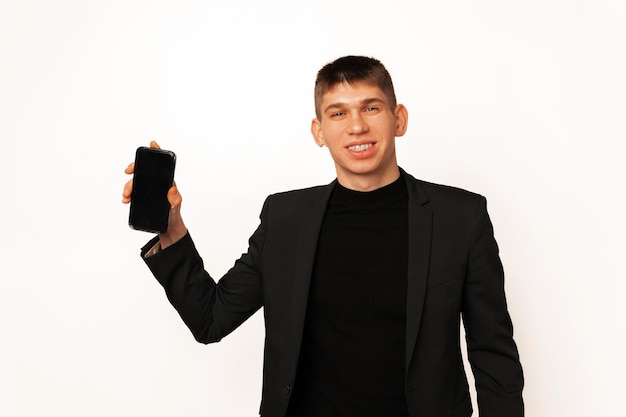 Schöner Mann zeigt der Kamera einen leeren Telefonbildschirm mit Kopierraum