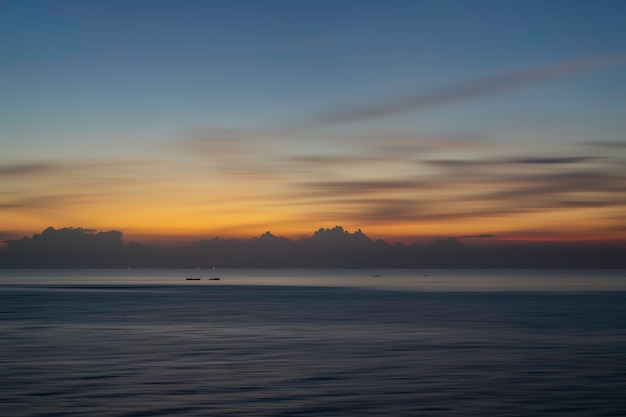 Foto schöner meerblick mit boot im meer bei sonnenuntergang oder sonnenaufgang. natürliches licht.