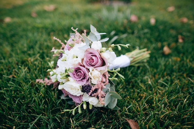 Schöner moderner weißer und rosa Hochzeitsblumenstrauß auf grünem Gras