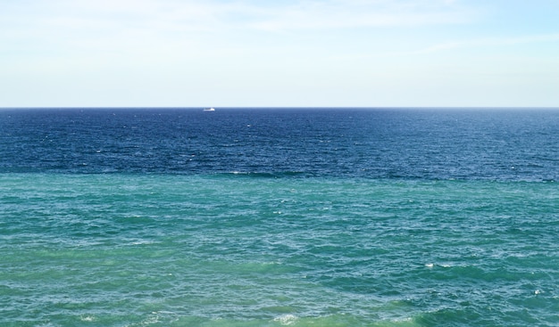 Schöner natürlicher blauer Himmel, der an einem sonnigen Tag über den Horizont über das ruhige Meer geht.