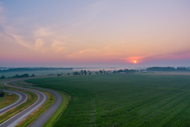 Schöner nebliger Sonnenaufgang Landschaft nebliger Morgen auf malerischer Wiese mit Luftbild