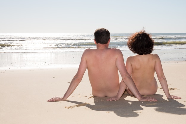 Schöner Nudismuspaar-Natrurismus in der Liebe am Strand nackt auf dem Meer