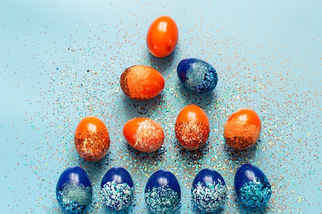 Schöner Ostern blauer Hintergrund mit blauen und orange dekorativen Eiern.