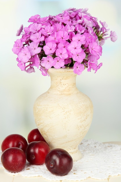 Schöner Phloxstrauß in Vase auf dem Tisch auf hellem Hintergrund