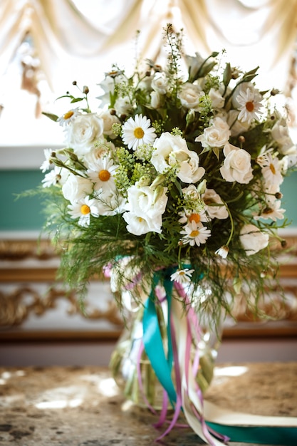 Schöner romantischer Blumenstrauß der weißen Blumen mit Kamille im luxuriösen Interieur