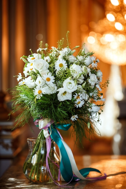 Schöner romantischer Blumenstrauß der weißen Blumen mit Kamille im luxuriösen Interieur