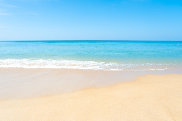 Schöner sandiger Strand und tropisches Meer mit blauem Himmel am Sommertag.
