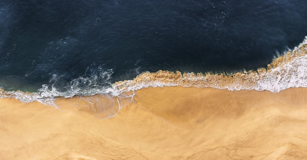 Foto schöner sandstrand draufsicht panoramablick auf den sandstrand die meereswelle rollt am ufer blick auf die meeresküste aus der luft luftaufnahmen der meereswelle das meer und der strand kopieren sie platz