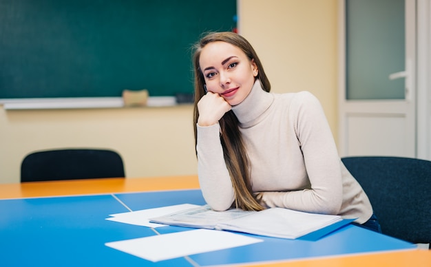 Schöner Schullehrer, der im Klassenzimmer sitzt