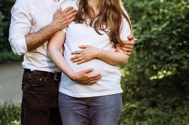 Schöner schwangerer Bauch. Mann und seine schöne schwangere Frau umarmen sich.