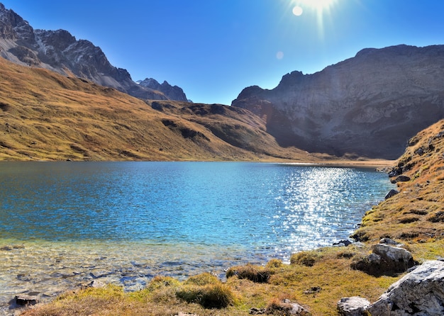 Schöner See im alpinen Bergsee mit der Reflexion der Sonne auf dem Wasser
