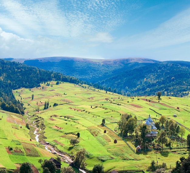 Schöner Sommerberg und kleines Dorf am Berghang der Karpaten in der Ukraine