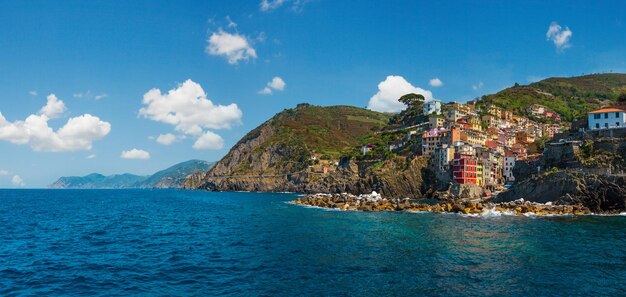 Schöner Sommerblick auf die Manarola-Küste vom Ausflugsschiff Eines der fünf berühmten Dörfer des Nationalparks Cinque Terre in Ligurien Italien, das zwischen dem ligurischen Meer und dem Land auf steilen Klippen aufgehängt ist