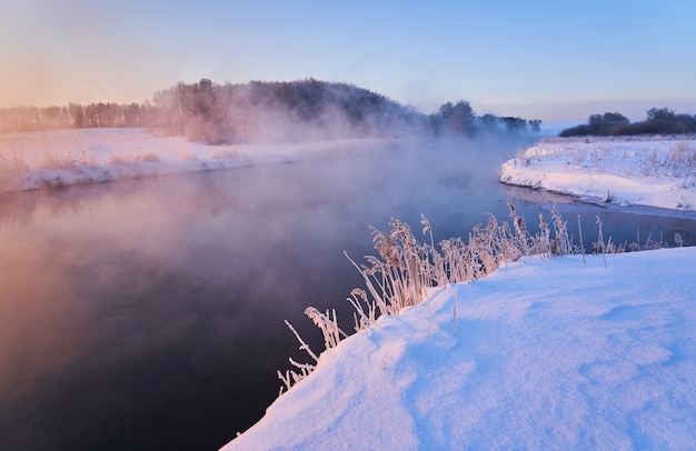 Schöner Sonnenaufgang auf dem Fluss im Nebel im Winter