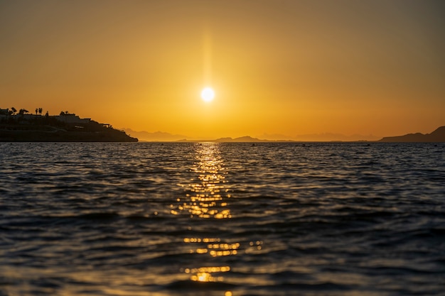 Schöner Sonnenaufgang über dem Meerwasser in Sharm El Sheikh, Ägypten. Reise- und Naturkonzept. Morgenhimmel, Sonne und Meerwasser