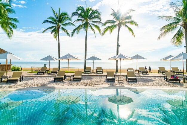 Schöner Sonnenschirm und Stuhl rund um den Pool im Hotel und Resort